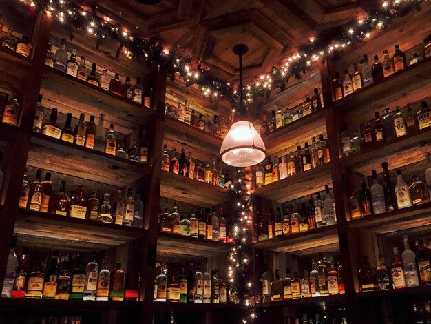 Illuminated shelves displaying bottles in bar